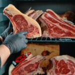 Raw steaks in meat aging refrigerator
